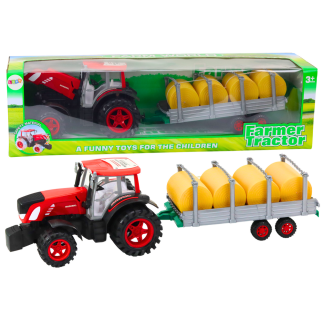 Duży traktor rolniczy z przyczepą i balami siana napęd czerwony