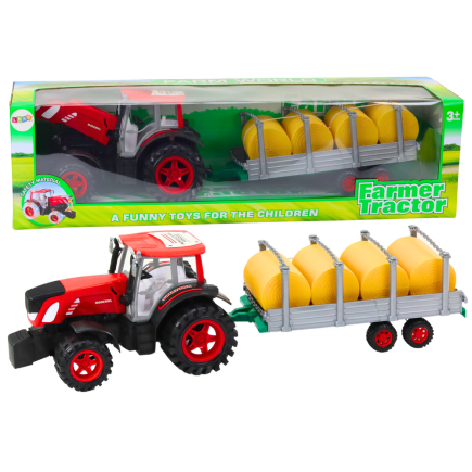 Duży traktor rolniczy z przyczepą i balami siana napęd czerwony